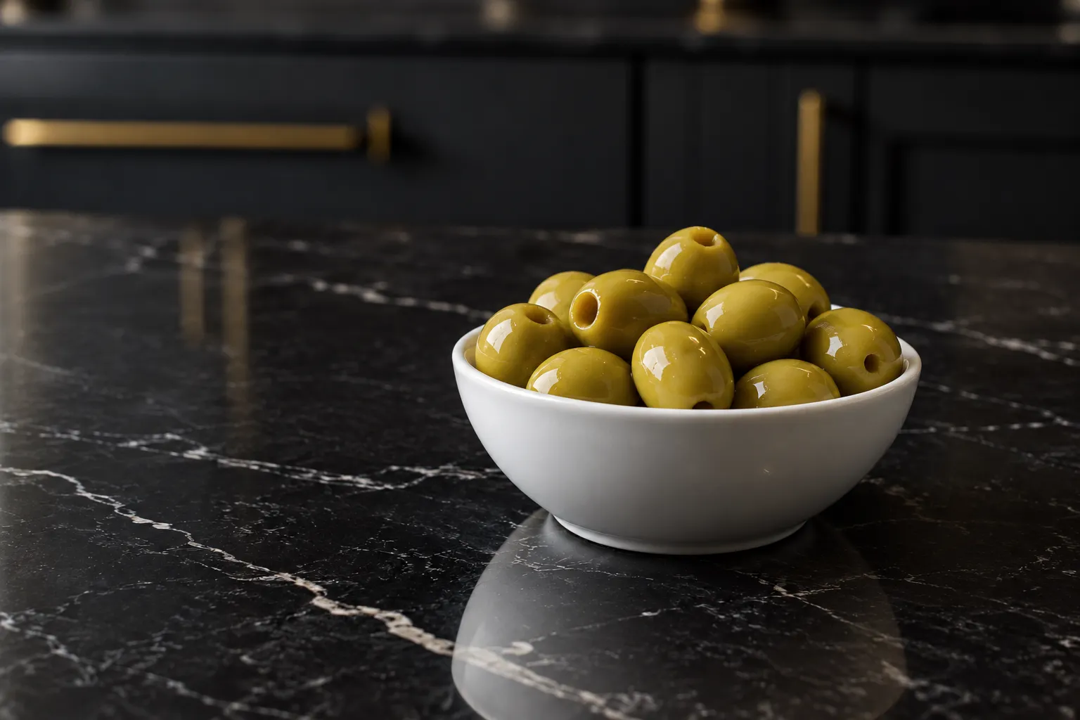 Aceitunas verdes deshuesadas en un cuenco blanco sobre mármol negro