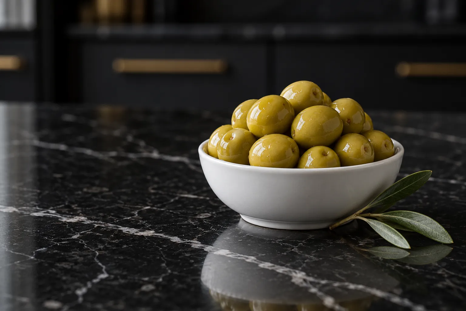 Aceitunas Manzanilla verdes y redondas en un cuenco blanco sobre mármol negro